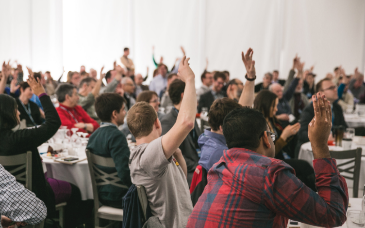 Participants at an event raising their arms